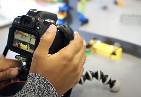 Student's hands adjusting camera for animation 