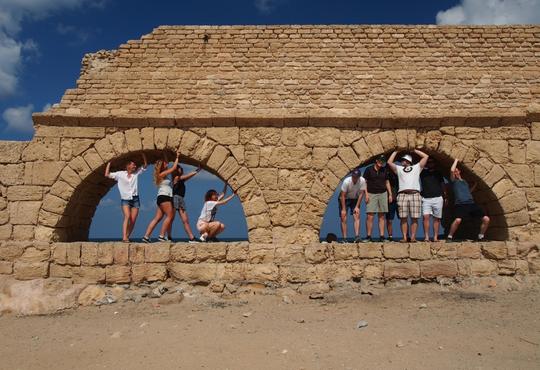 students posing in ancient building arches in Isael