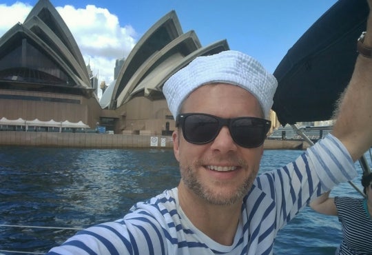 Patrick Hofmann on a boat in front of the Sydney Opera House