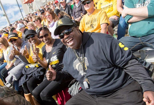 fans at the football game wearing black and gold