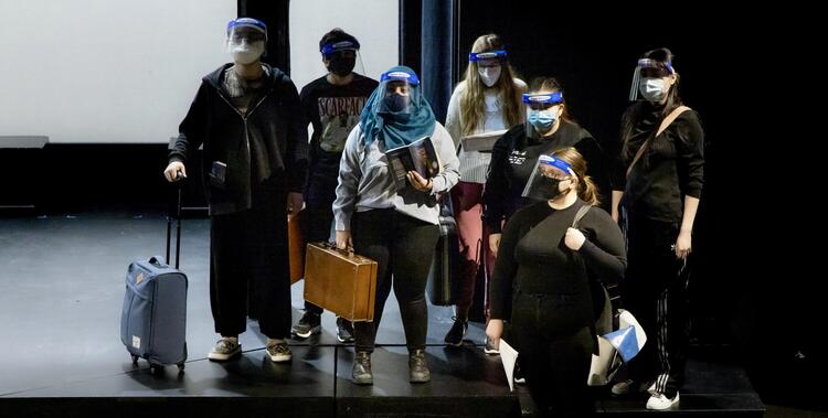 seven student actors on stage in mask and faceshield