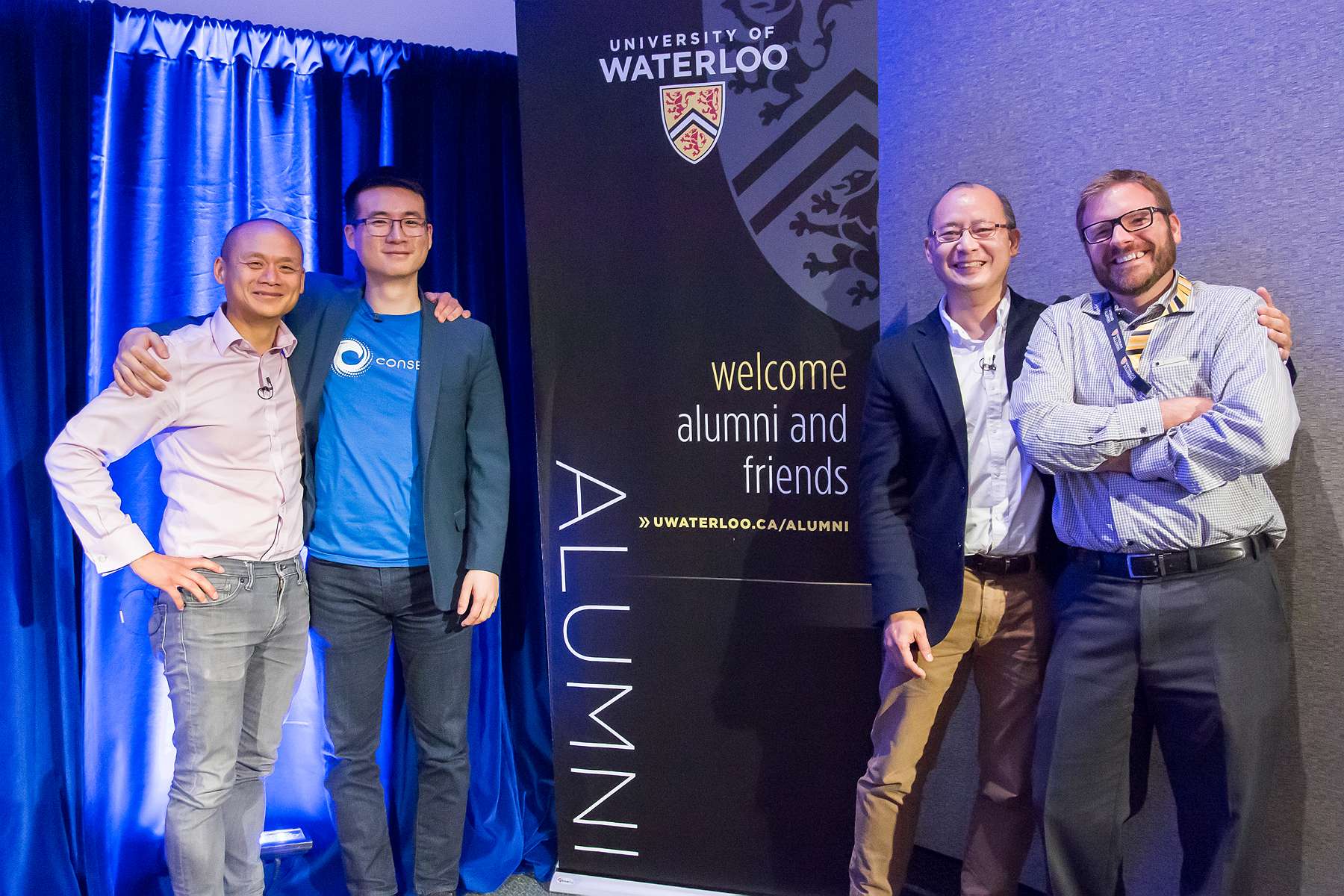 Vincent Lam and audience members pose with the alumni banner