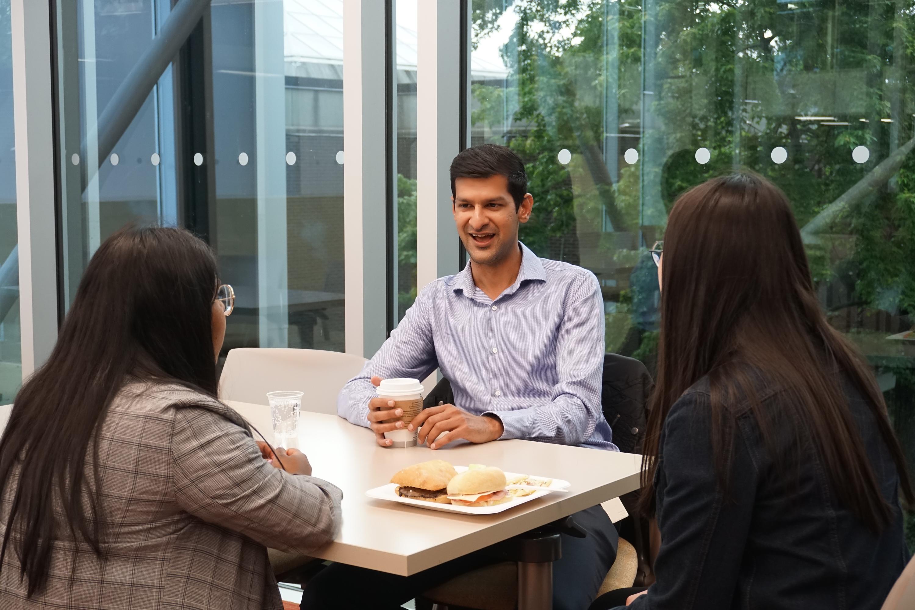 Ayaz Gullamhussein speaks with students at table