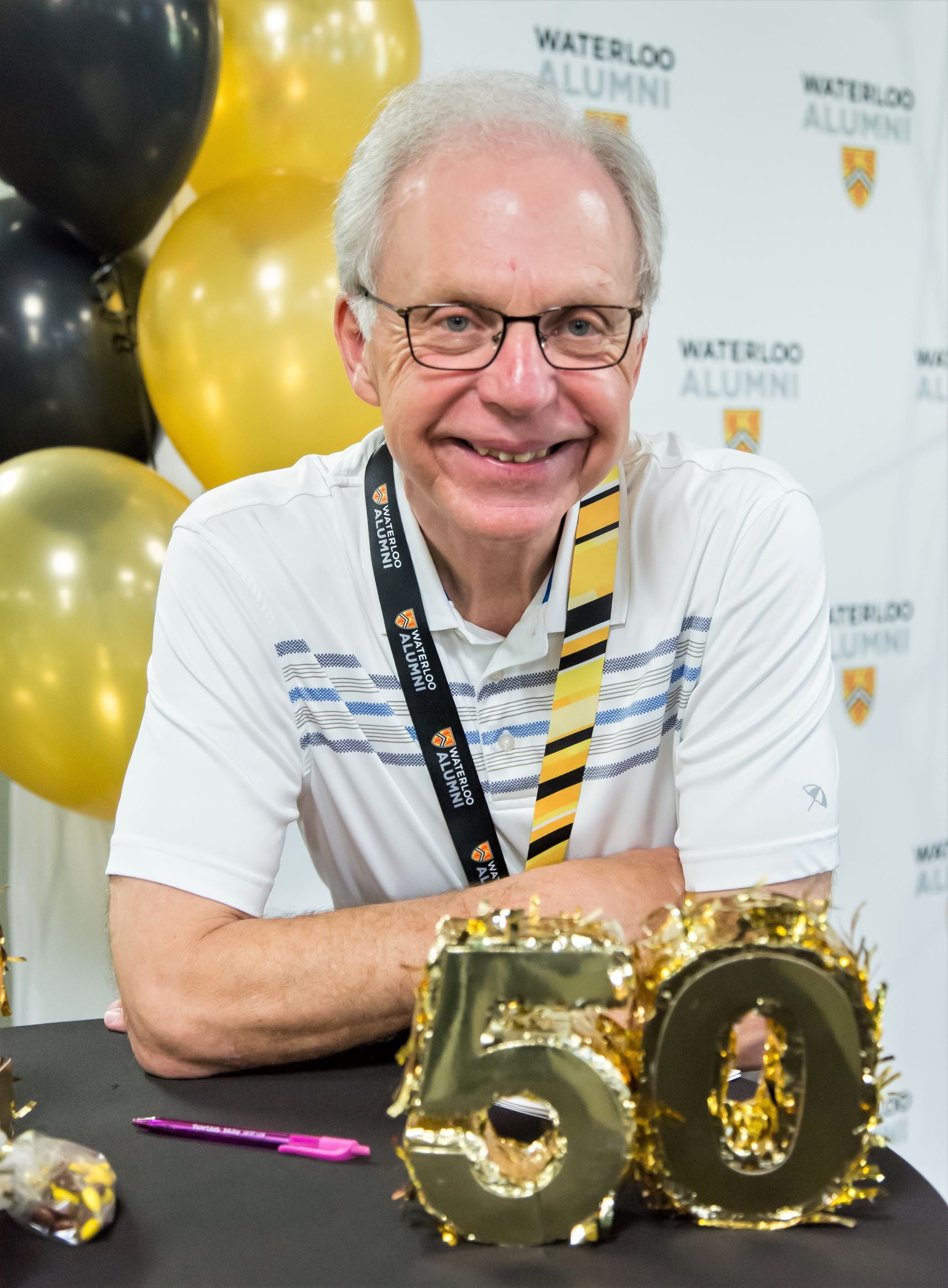Daryl Smith smiles with gold 50 and ballons