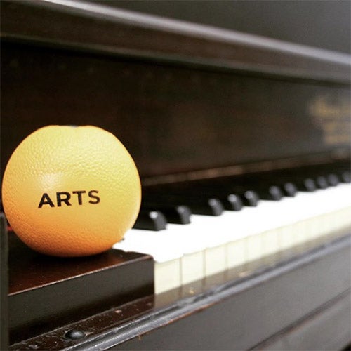 an orange sitting on a piano keyboard