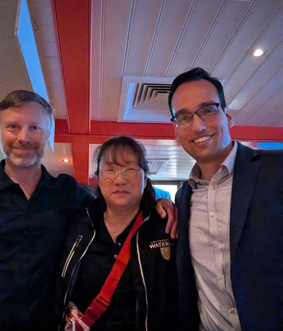 Eric Wragg, Phoebe Wong, and David Isern stand in a pub