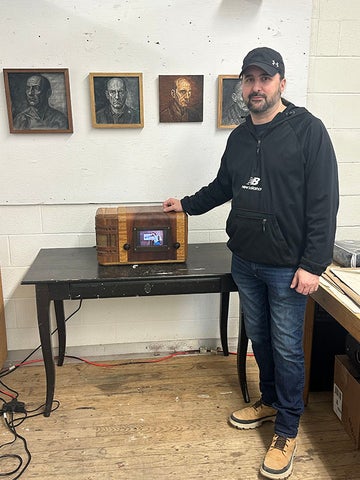 James Mazlahn in his studio, posing with a device made from a 1950s television set