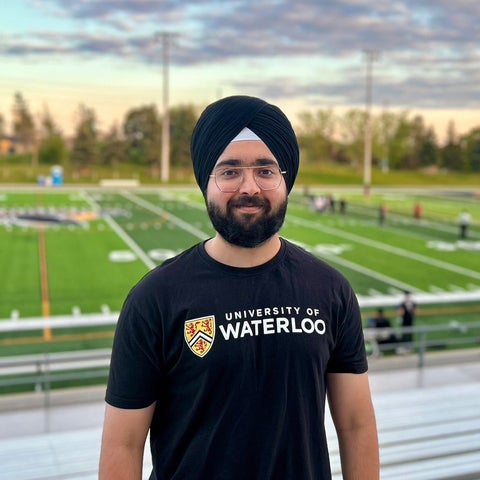 Sehaj Singh smiles in a UW shirt in front of Warriors Field