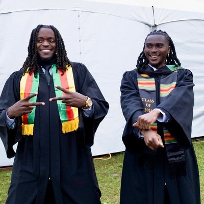 two student representing cultural apparel for convocation 