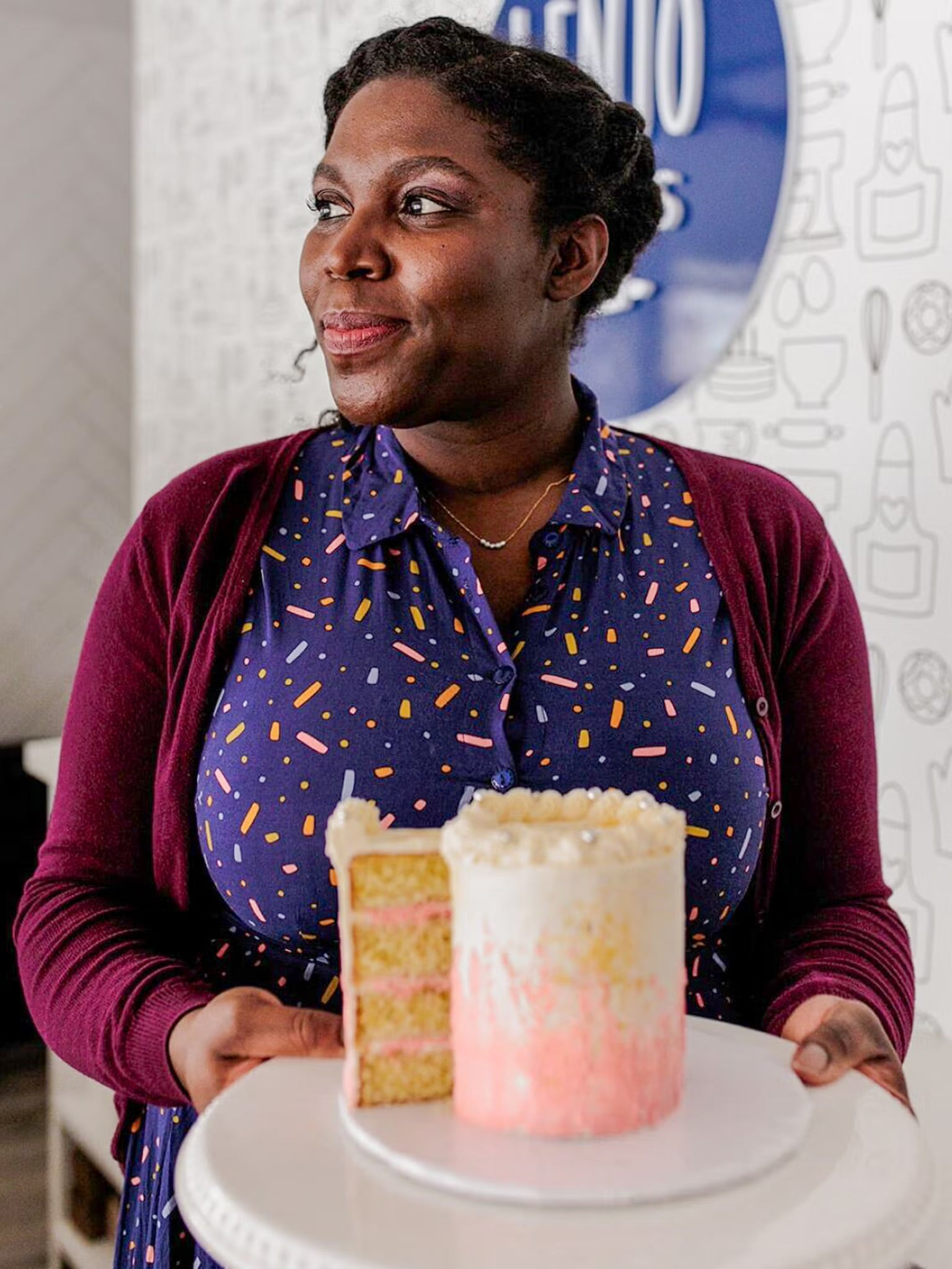 Lenore Johnson holds a pink and white cake