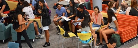 students gathered in social space with comfortable seating