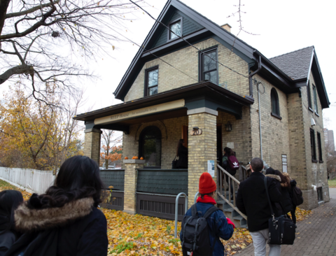Students approach the REEP House - a historic, gold brick century home