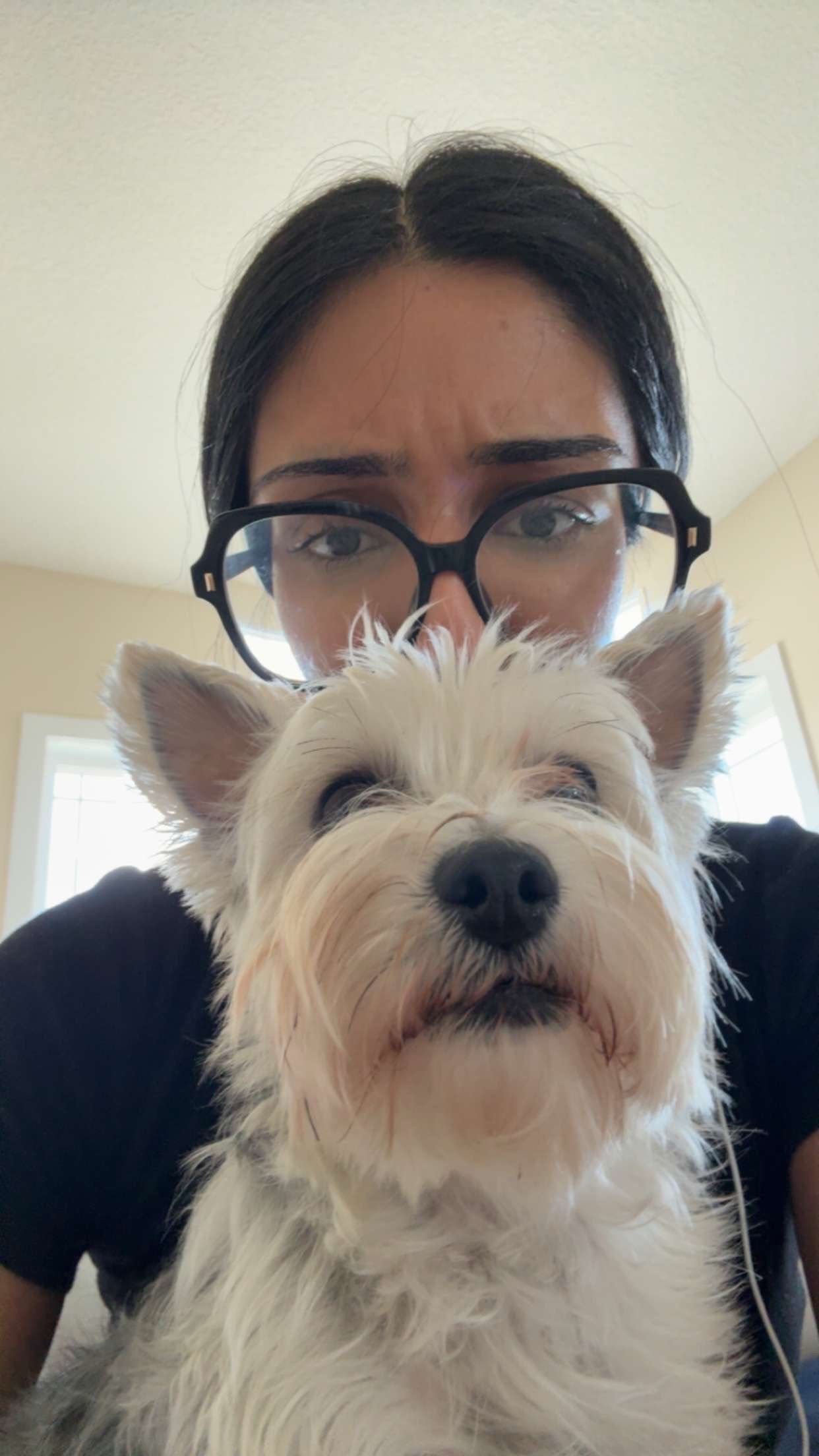 Raj with a small white dog sitting in front of her