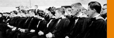 Archival photo of a row of Waterloo's first graduands sitting in a row wearing their gowns and hoods.