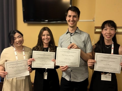 Four students holding certificates