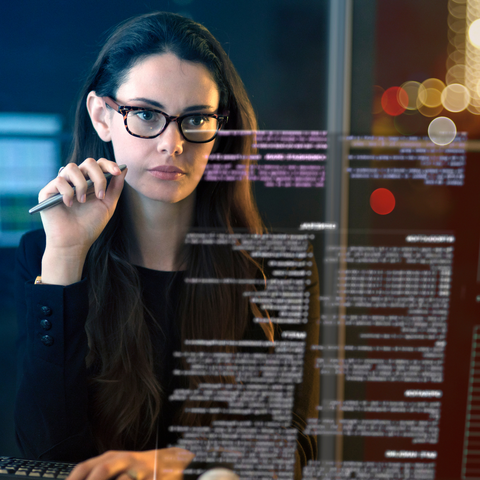 A woman reads through a screen of text and data