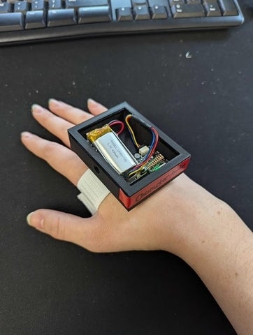 A skall box filled with electronics strapped to a hand