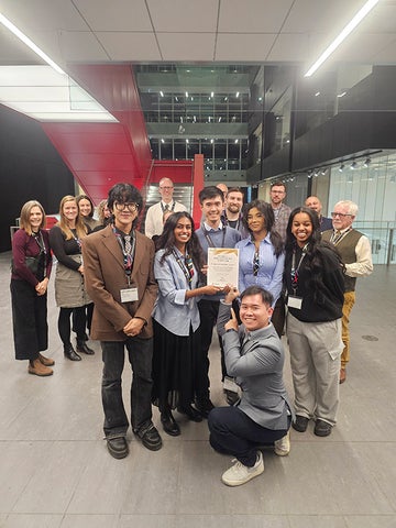 A group of students hold up their award at the Global Engagement Seminar