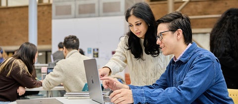 Two students look at a laptop in Hagey Hub