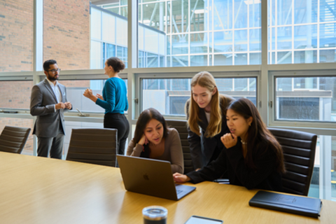 A group of people working in the School of Accounting and Finance boardroom