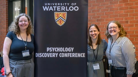 three women with Psychology Disovery Conference banner