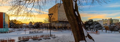 A snow covered Arts Quad featuring Dana Porter library and a University of Waterloo Sign