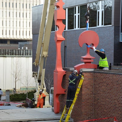 construction workers detach the sculpture from the wall
