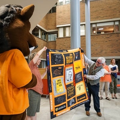 Doug and Porcellino holding a quilt