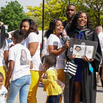 Family wearing matching t-shirts celebrating with graduate