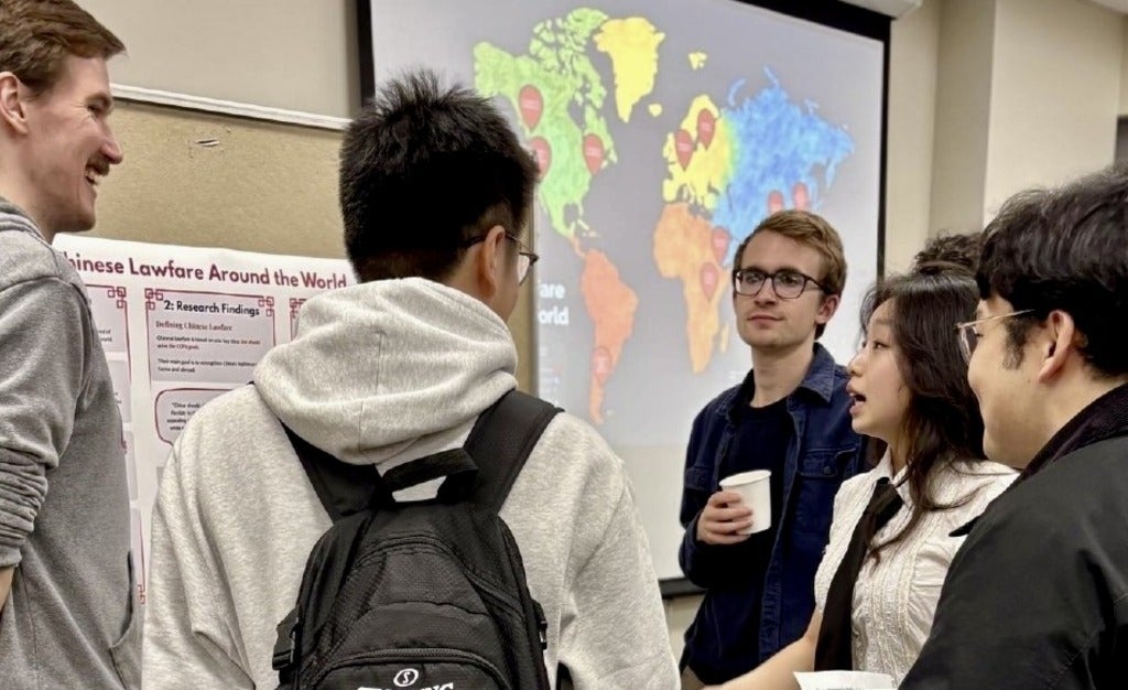 Group of students talking in front of posters