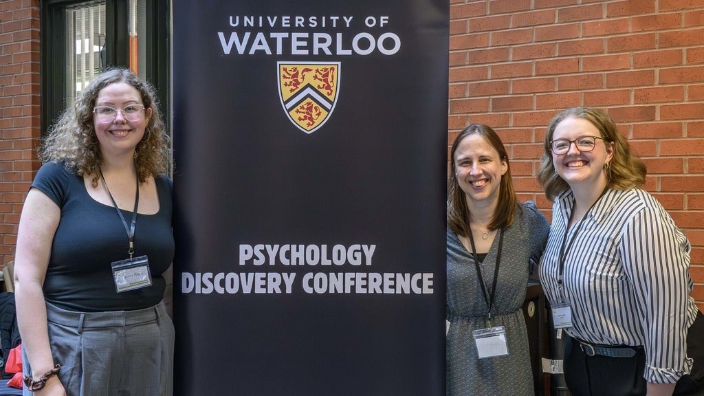 three women with Psychology Disovery Conference banner