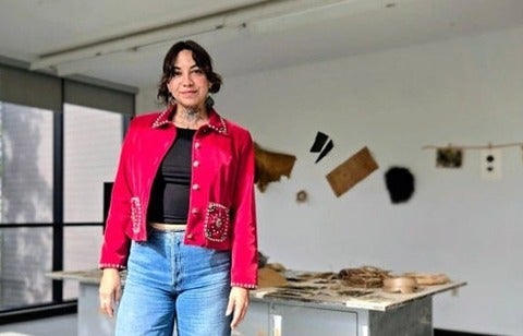 Amber Sandy in a studio space with big windows and art hanging on the wall