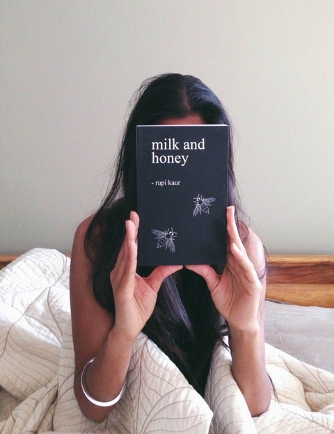 Rupi Kaur holds her book of poetry