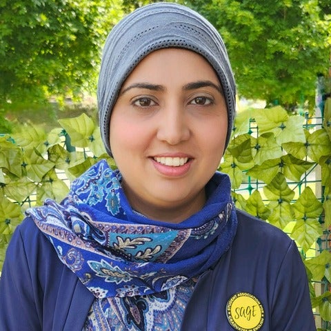 student standing in front of greenery