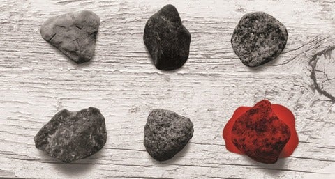 stones against wood surface, with one stone in blood red