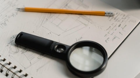 an open notebook with a magnifying glass and a pencil