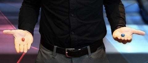 person's hands holding red and blue pills