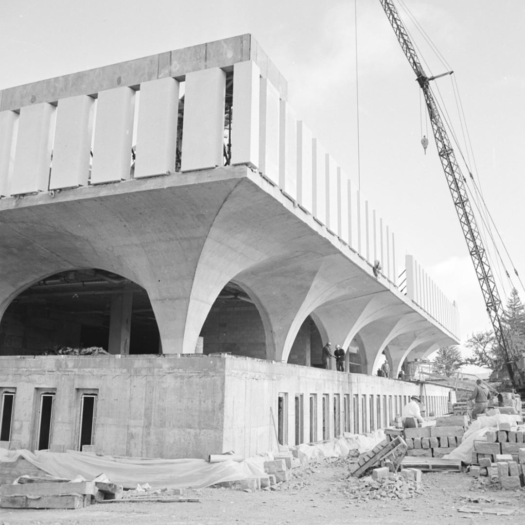 Black and white photo of a one-story DP with a crane beside it