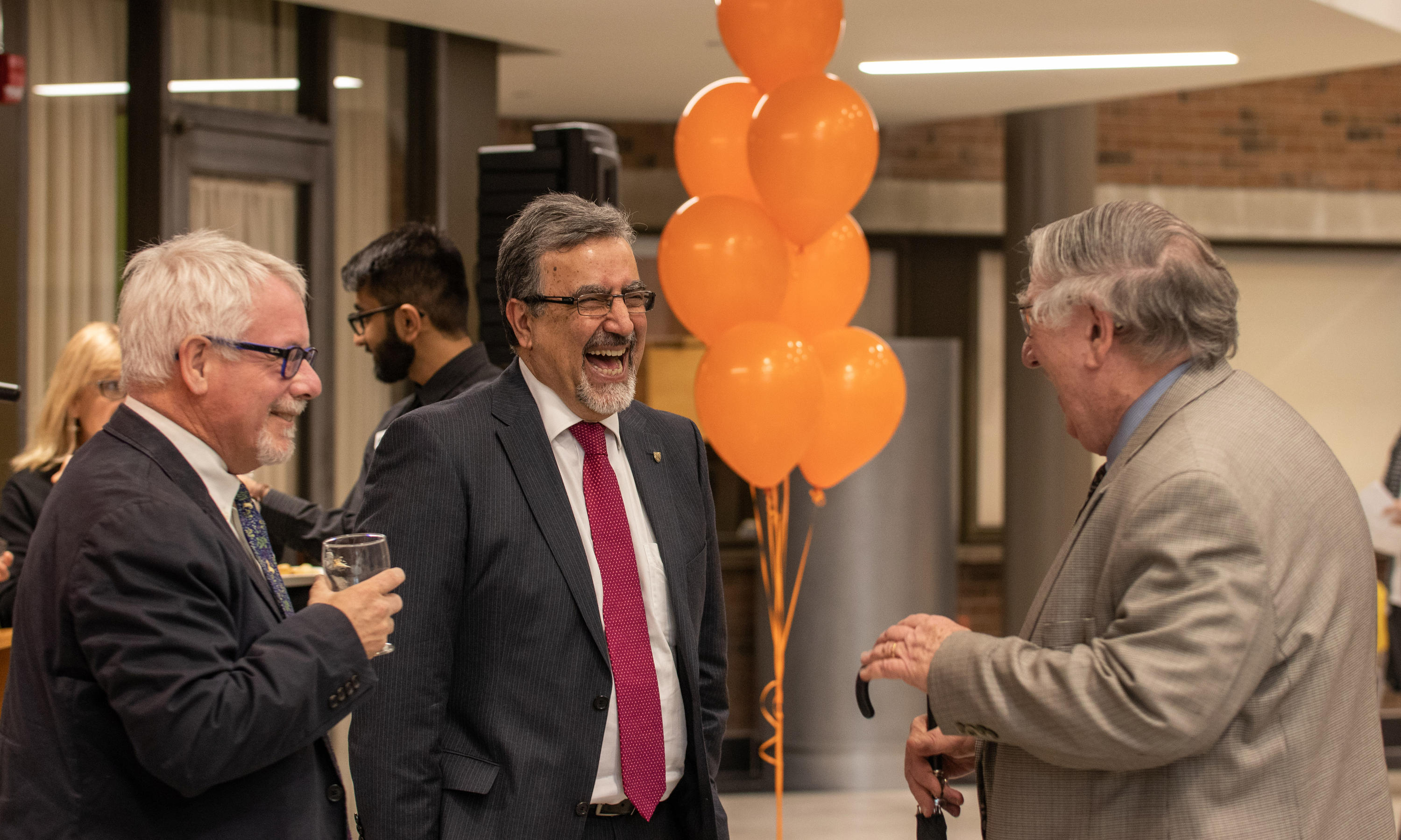 dean of arts, president and provost laugh together