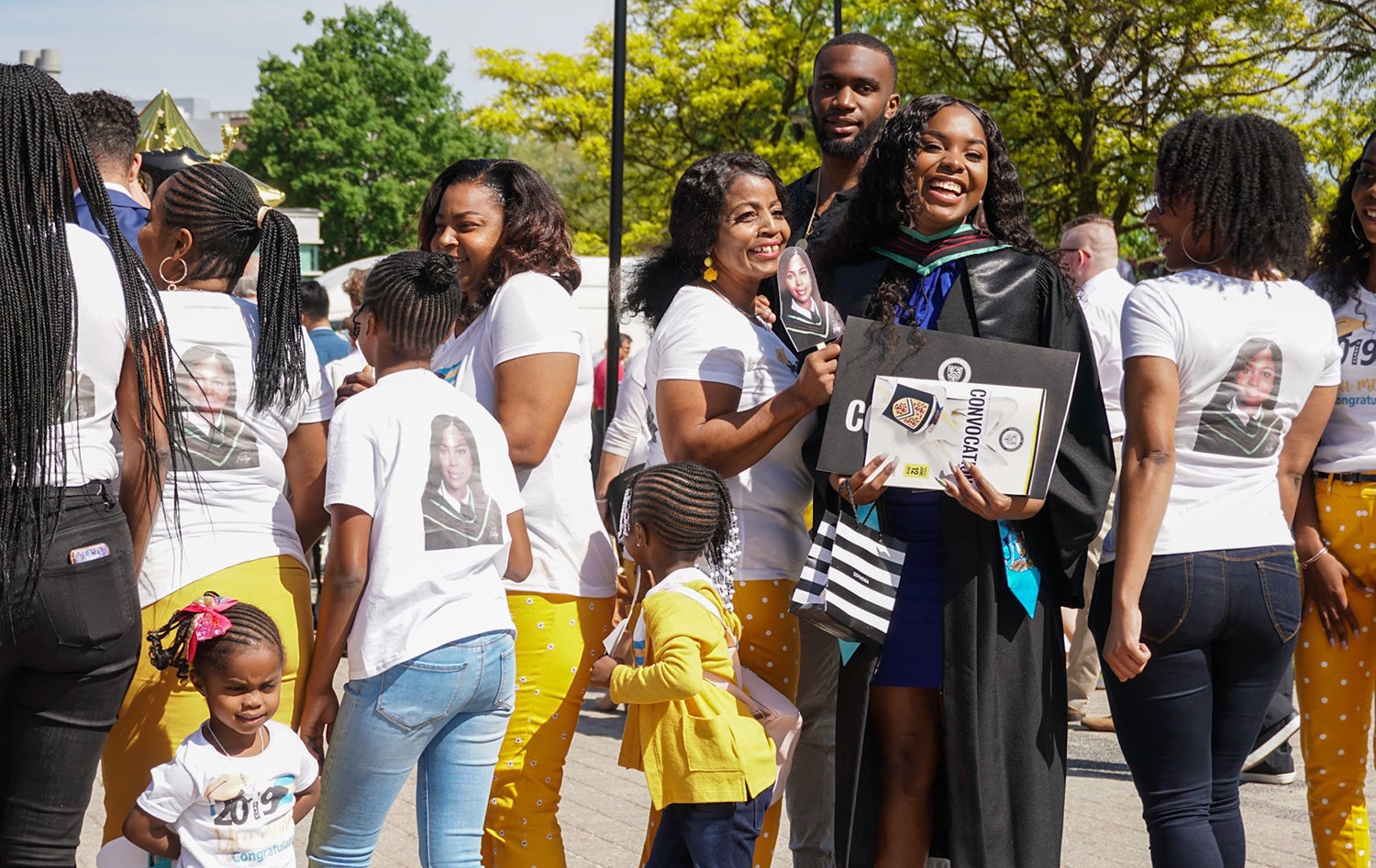 Family wearing matching t-shirts celebrating with graduate