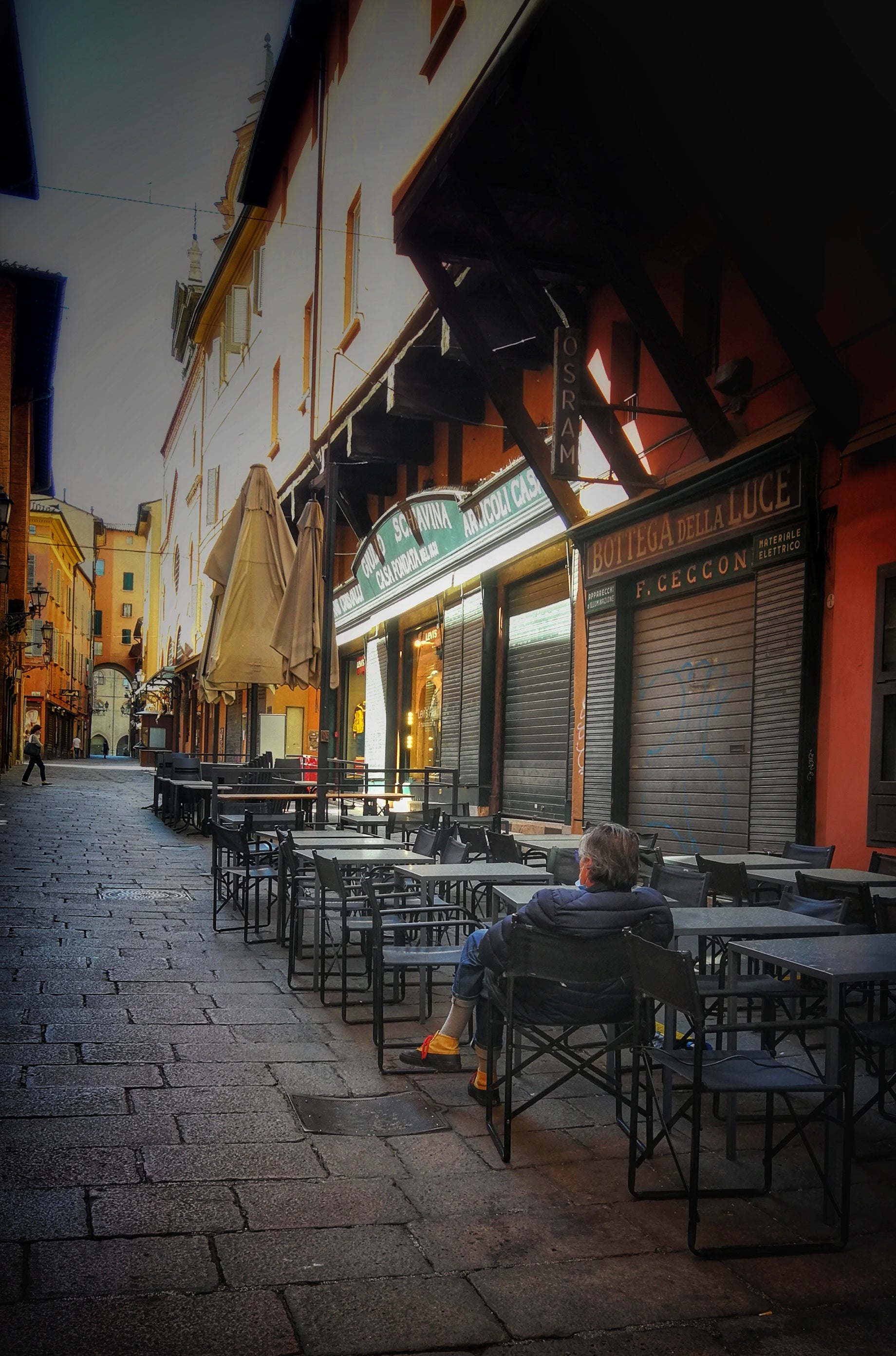 Man sits alone outside closed cafe