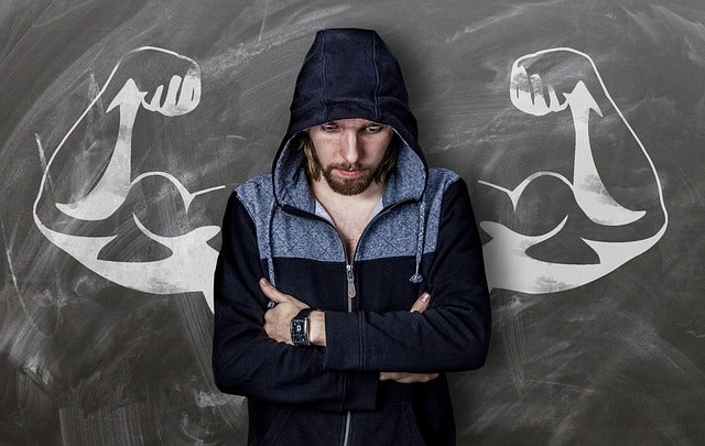 man looking down set against drawing of a muscular set of arms