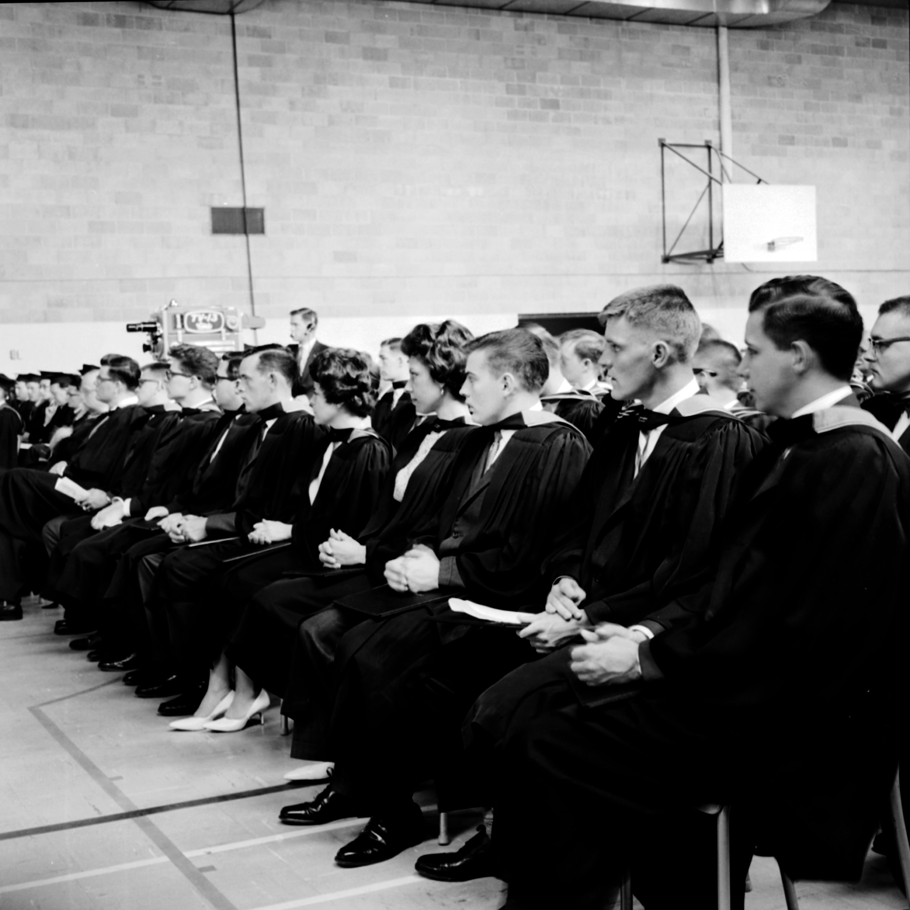 Circa 1960s graduates sitting in row