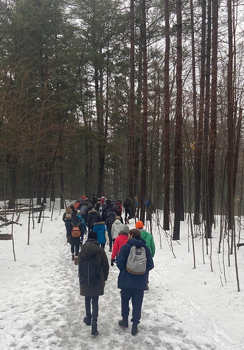 Students walking in the woods on snow winter day