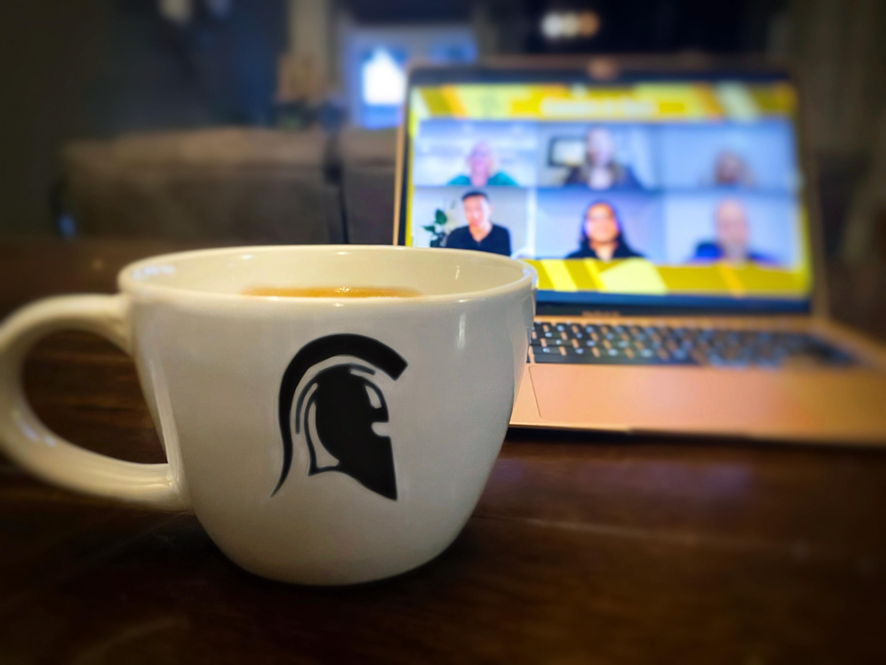 Waterloo Warriors logo mug in front of computer with Zoom call