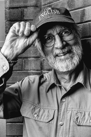 Randy Harris tipping his hat the the viewer. His hat says "Waterloo English"