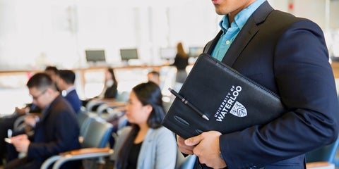 Student holding padfolio waiting for an interview