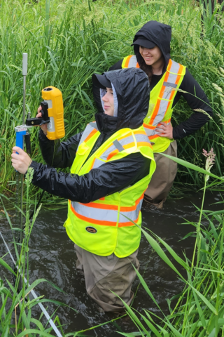 Two students taking samples on land during a co-op work term with GHD