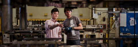 two students in a lab pointing