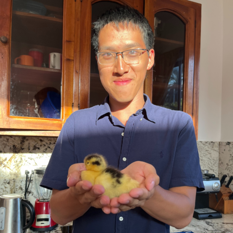 Kelvin smiling holding a duckling